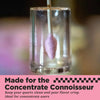A clear cylindrical glass container holding a small lavender-purple quartz atomizer hanging from a wooden stick, with a pink text banner at the bottom reading 'Made for the Concentrate Connoisseur'.