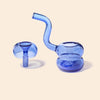 A pair of translucent cobalt blue glass water pipes, one with a curved neck and one with a straight mouthpiece, displayed on a solid pale beige background.