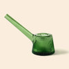 A NWTN Home translucent green glass water pipe with a ribbed, flared base and a long angled mouthpiece, shown on a solid light beige background.