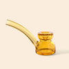 A translucent amber glass water pipe by NWTN Home with a curved mouthpiece and a double-bulb base, shown on a solid light beige background.