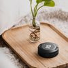 Black storage puck with Ongrok logo on a wooden tray with a plant in the background