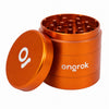 An orange metallic herb grinder with its lid off, showing the grinding teeth inside and the Ongrok brand name on the side, set against a plain white background.